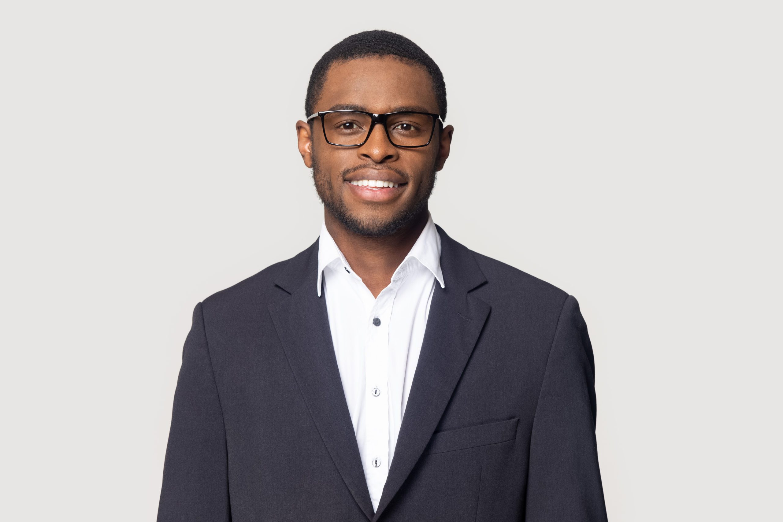 Smiling,African,American,Millennial,Businessman,In,Glasses,Isolated,On,Grey shutterstock 1437938108 scaled